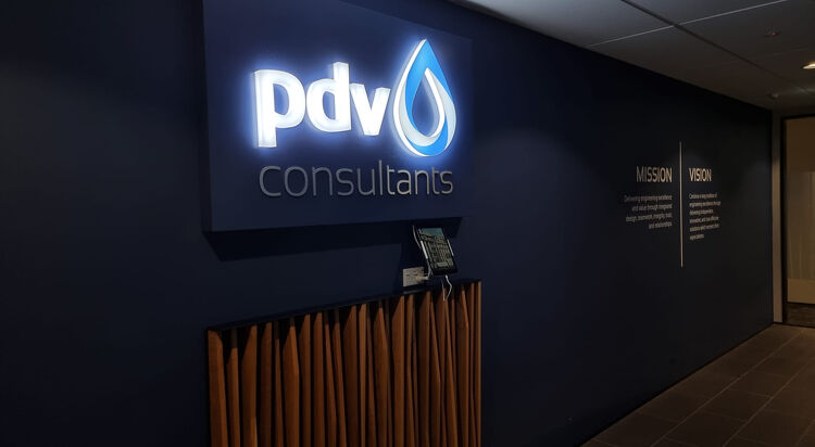 PDV Consultants illuminated sign in a reception area with mission and vision wall text